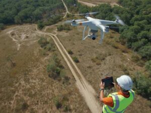 Drone surveying a large undeveloped parcel while a licensed land surveyor reviews aerial mapping data for site concept planning near St. Petersburg, Florida.