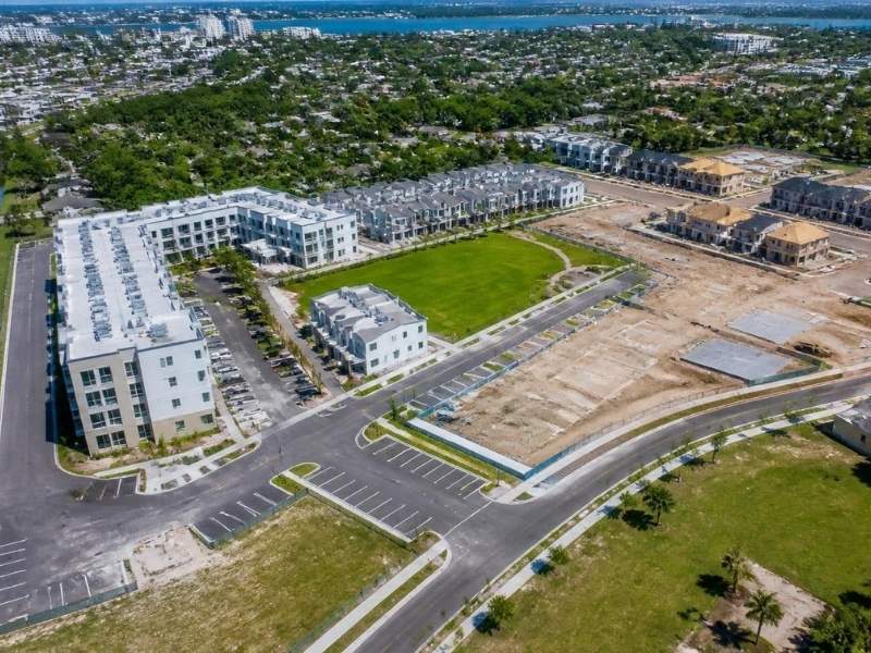Aerial view of phased townhome and condominium construction with completed buildings, active work areas, roads, and future pads in St. Petersburg, Florida.